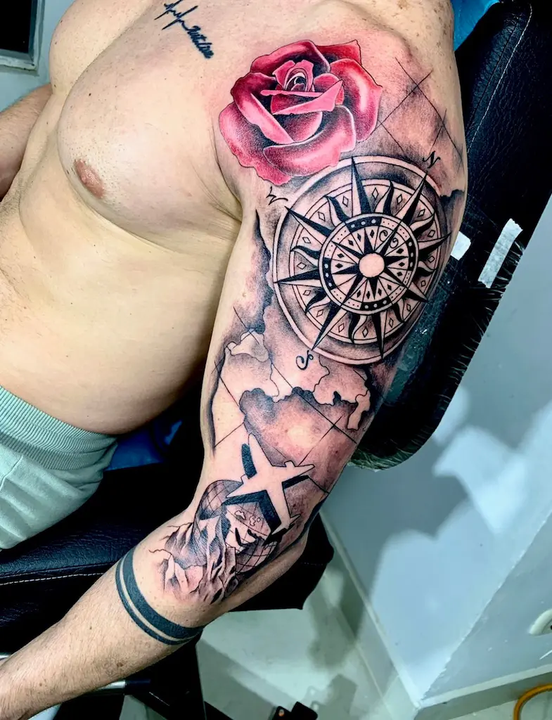 tatuaje en el brazo de una brújula con una rosa